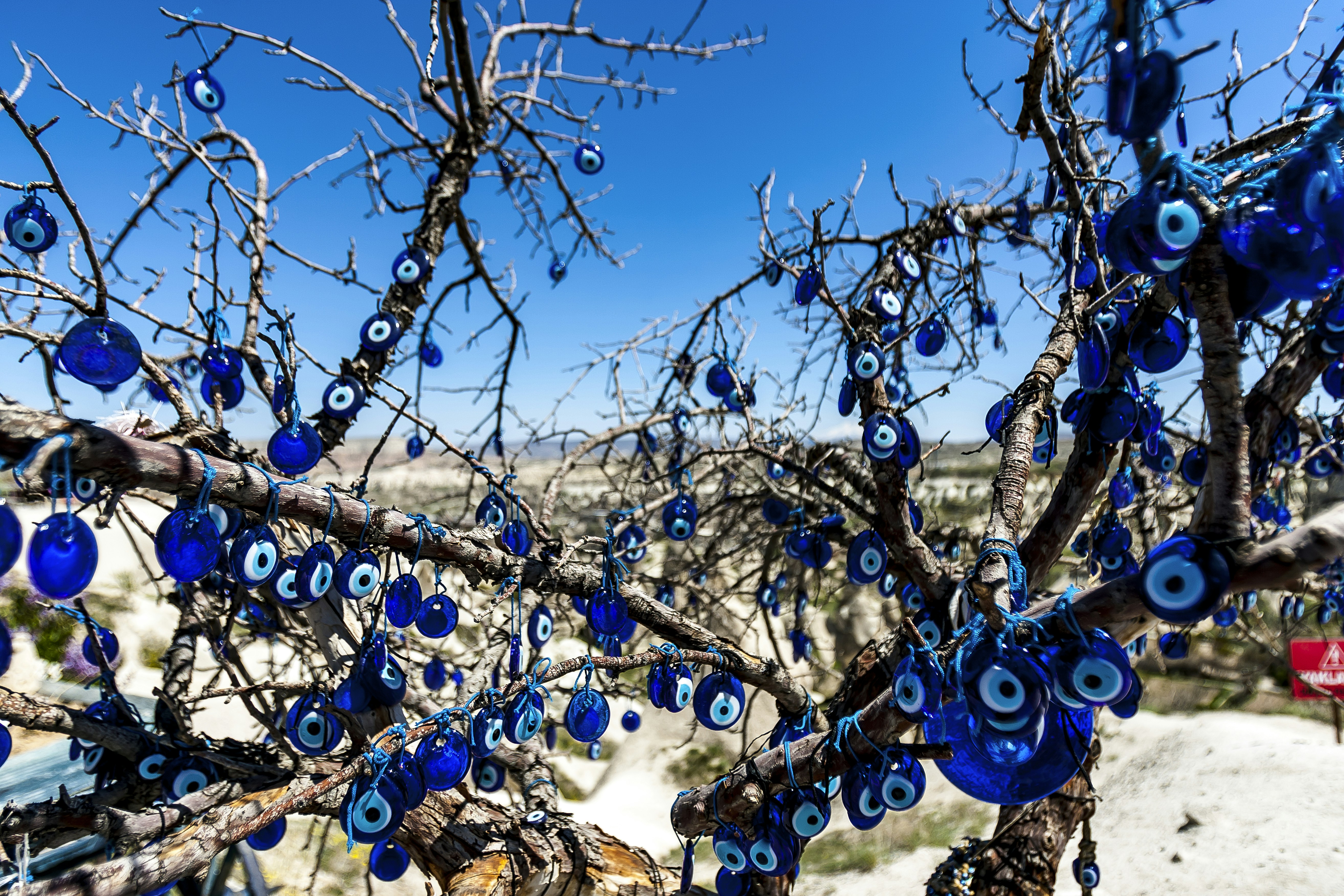 Overlooking the valley dotted with fairy chimneys, this pit stop boasted a souvenir shop as well as a cafe. Situated nearby was a tree strewn with blue evil eyes. Cappadocia, Kapadokya / Turkey: April 2017