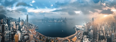 city buildings near body of water under cloudy sky