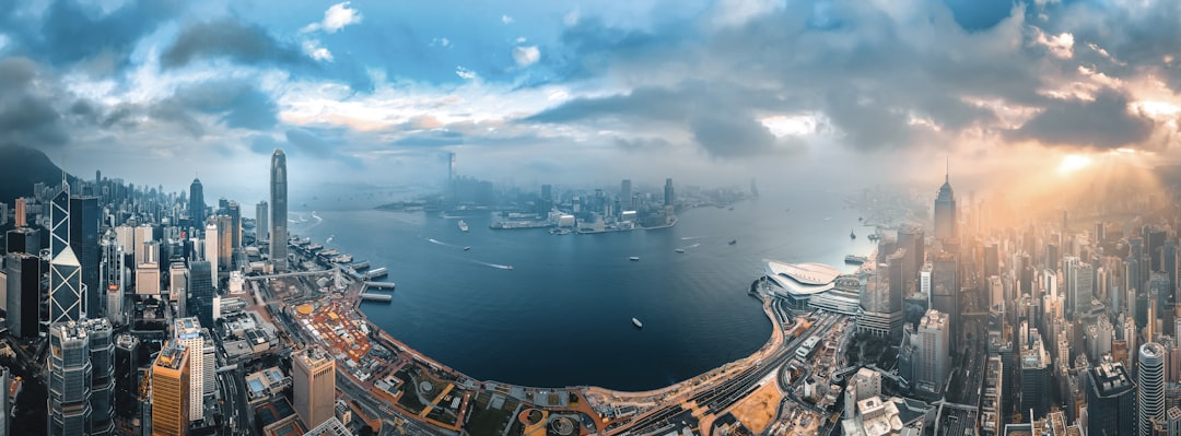 city buildings near body of water under cloudy sky, Hong Kong Island from aerial view in sunrise
