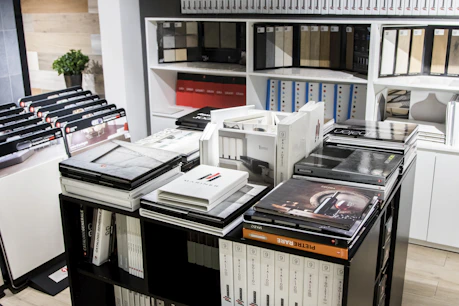 A professional team reviewing product catalogs in a modern office with Canadian flags visible.