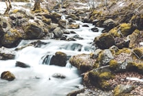 time lapse photography of river near rocks during daytime