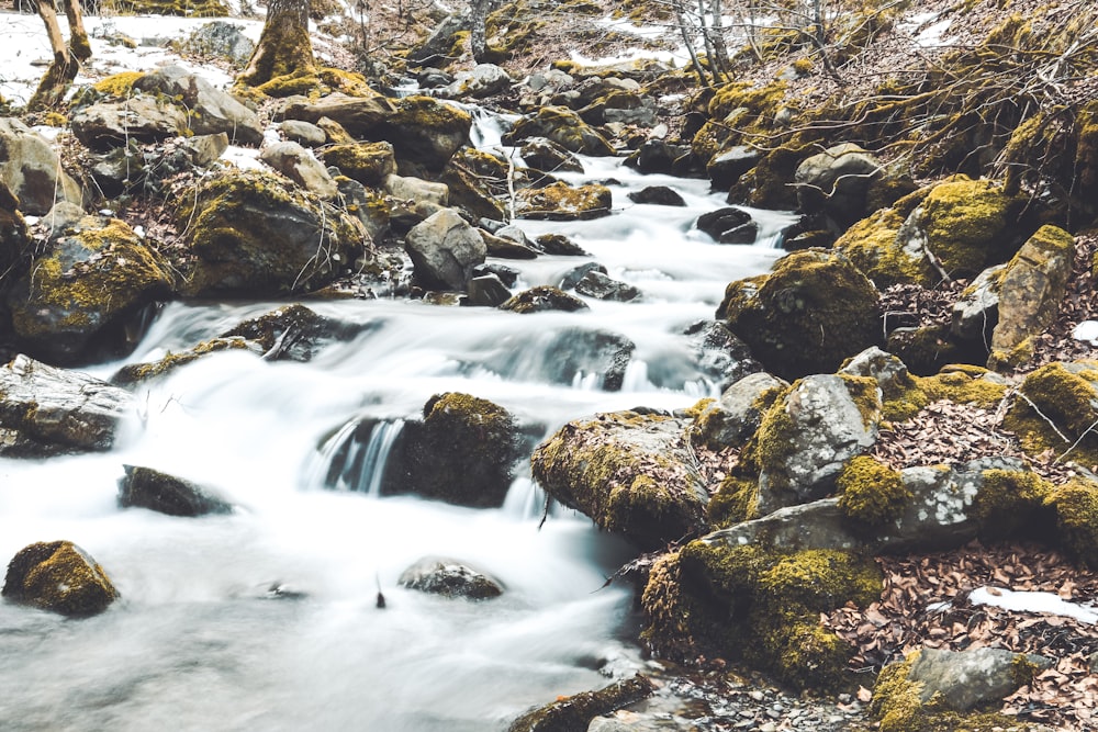 Fotografía de lapso de tiempo de río cerca de rocas durante el día