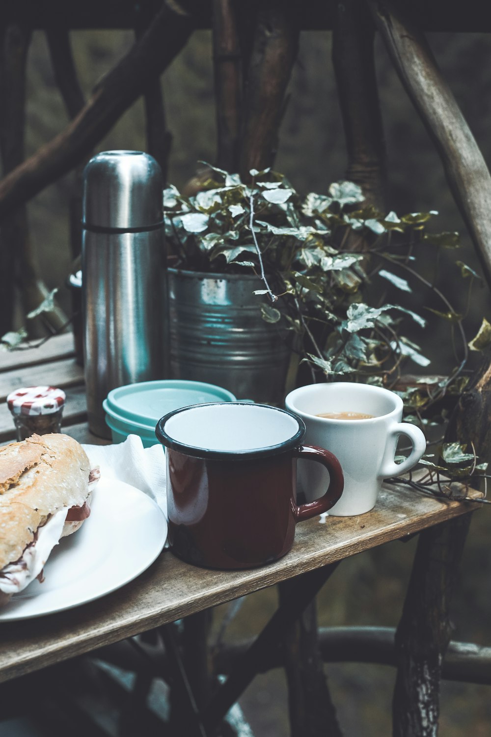 mugs beside plate with bread on table