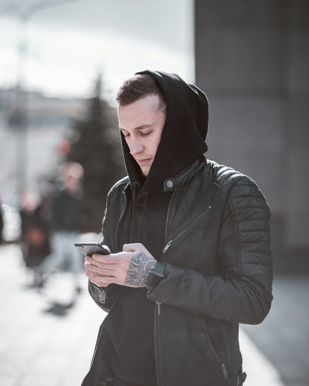 holding wearing black hoodie holding smartphone