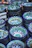 A colorful stack of hand-thrown ceramic bowls in shades of blue and green on a wooden table.