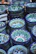 A colorful stack of hand-thrown ceramic bowls in shades of blue and green on a wooden table.