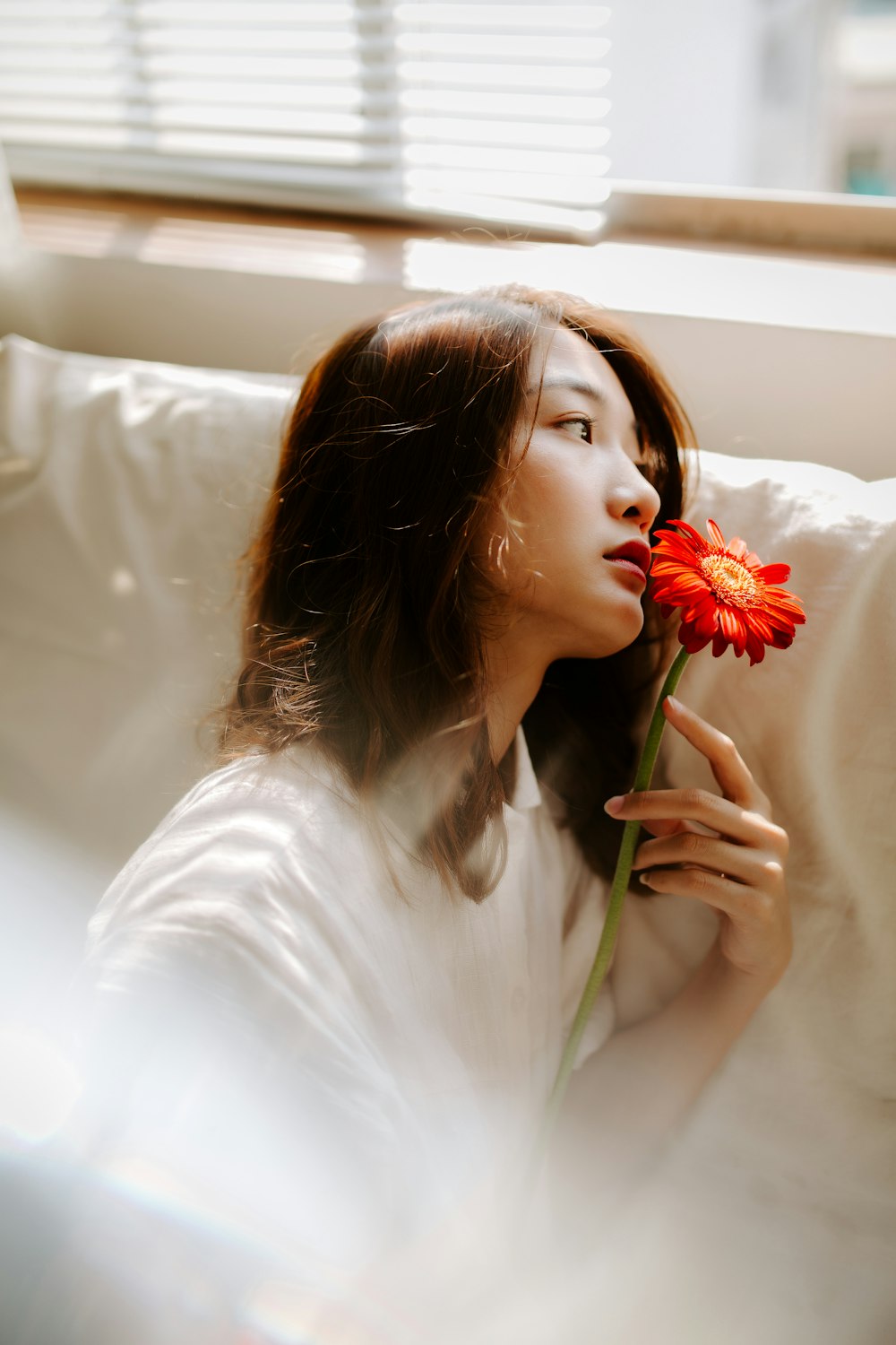 woman holding flower sitting on sofa