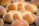 Freshly baked bread loaves with a golden brown crust, showcasing a variety of shapes including braided and round buns.