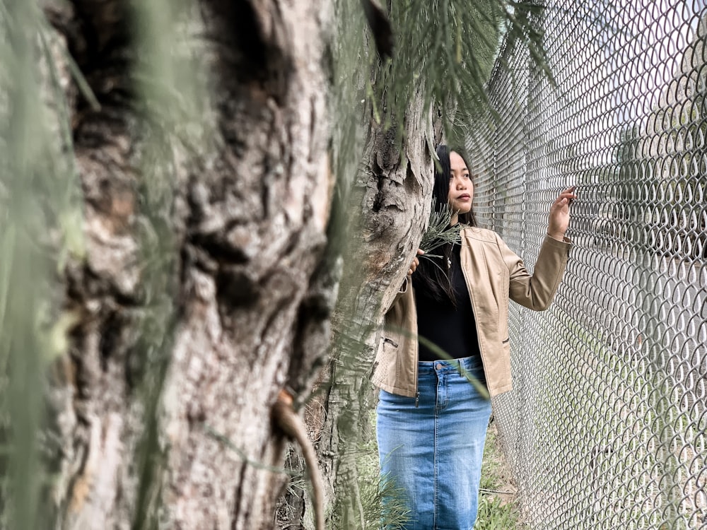 woman standing beside gray chain-link fence