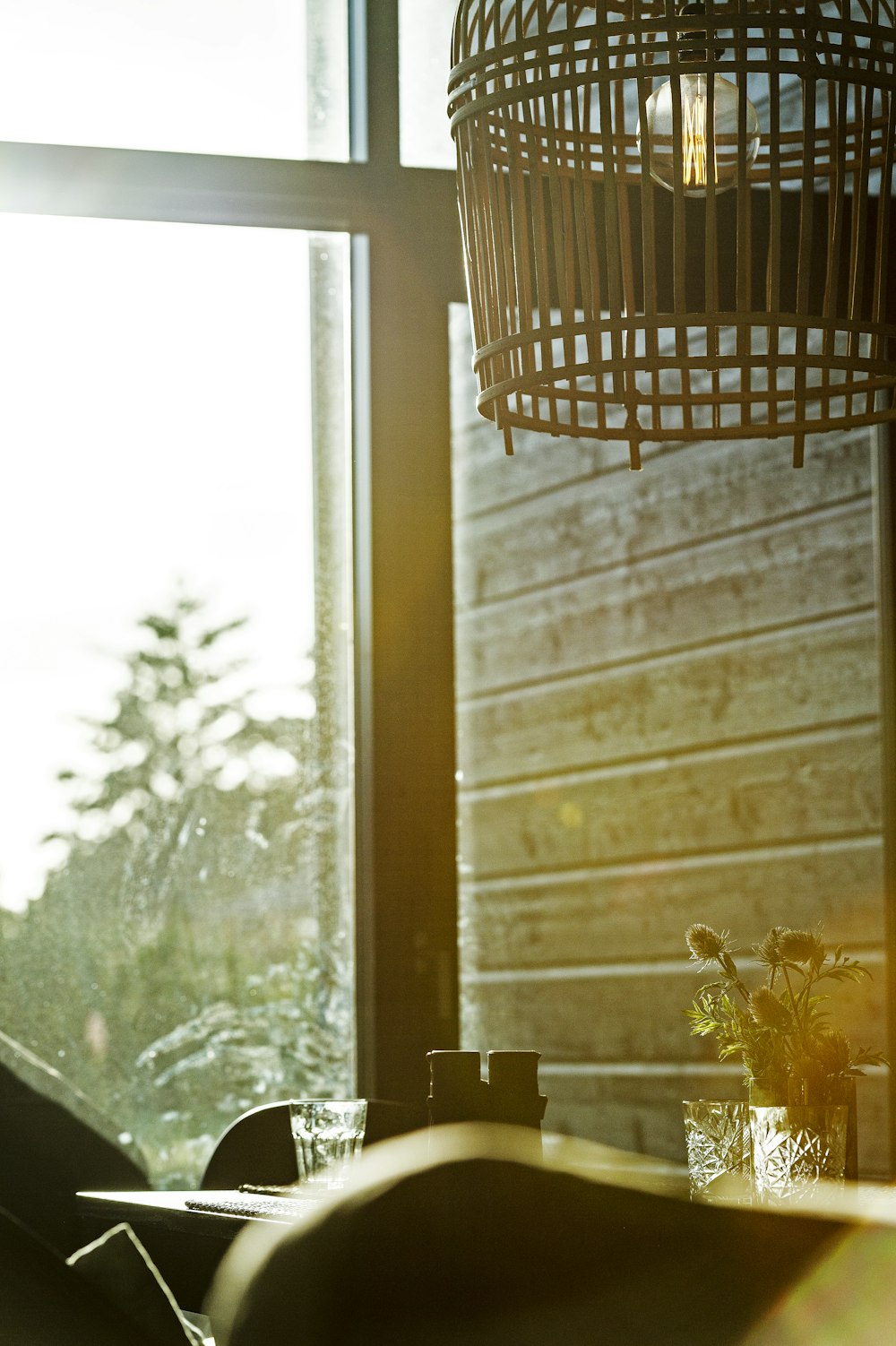 a birdcage hanging over a table next to a window