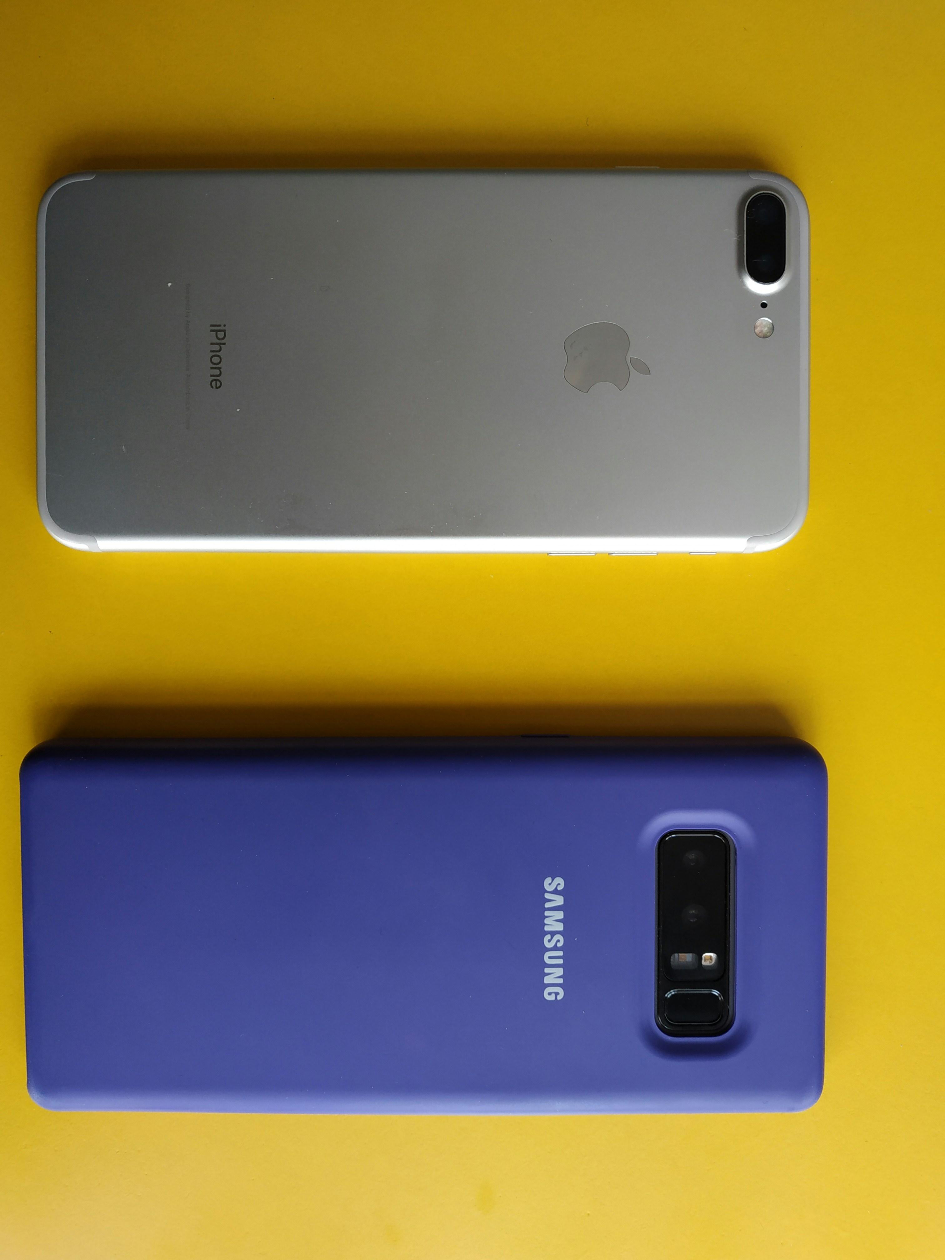 Apple iPhone and Samsung Galaxy phones side by side on white background