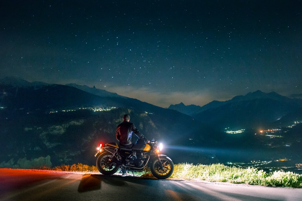 Mann sitzt nachts auf Motorrad