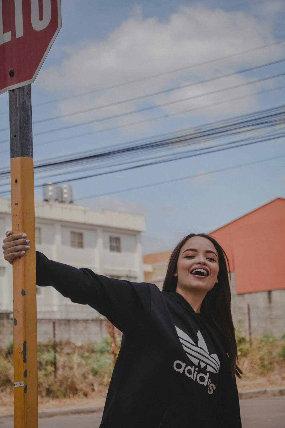 smiling woman holding road sigange