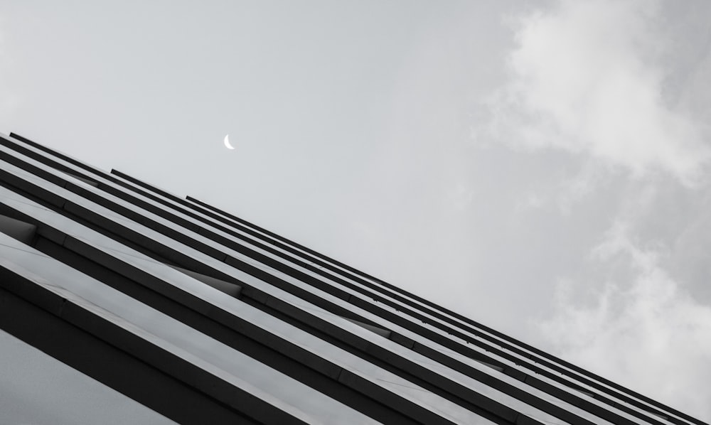 a tall building with a half moon in the sky