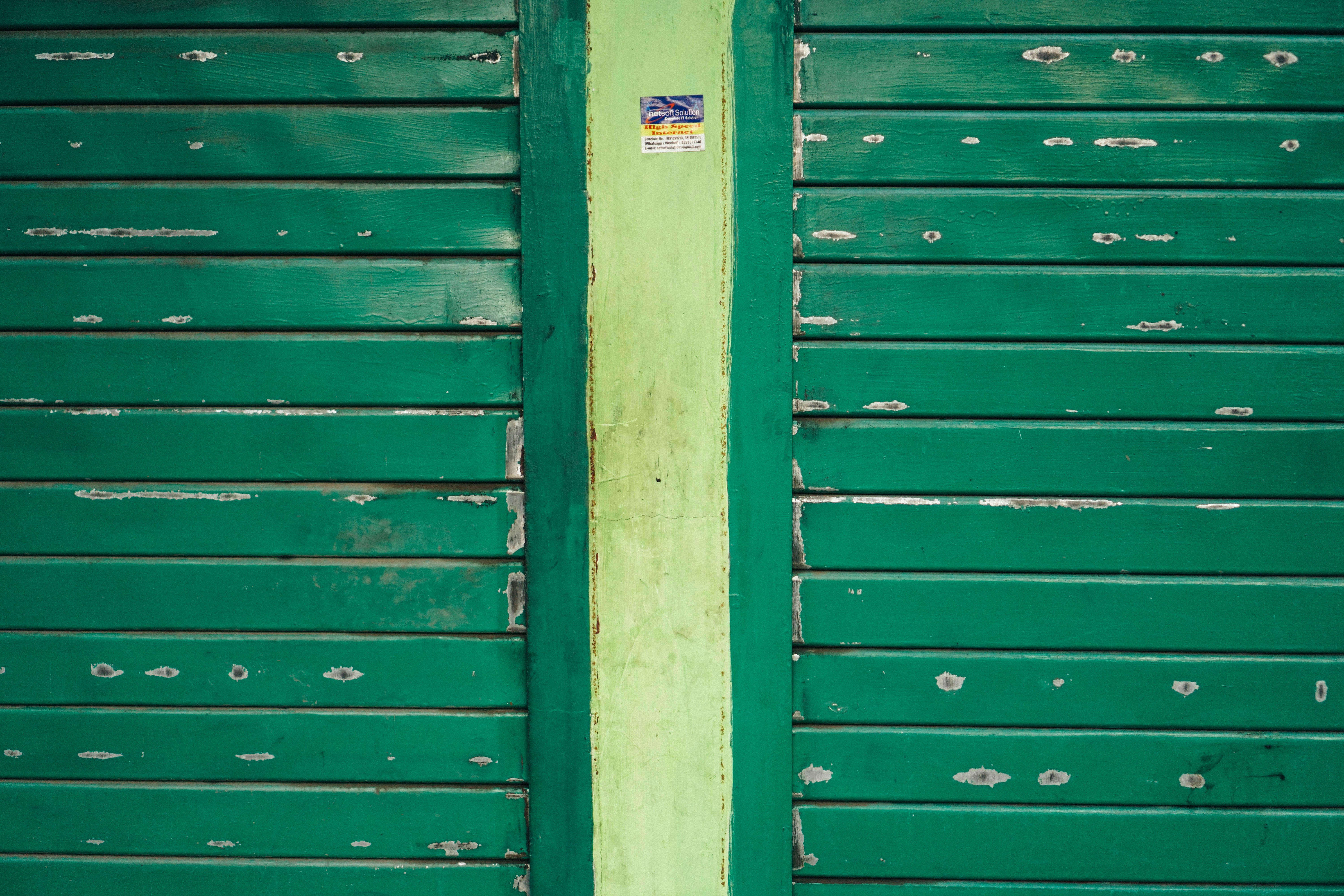 um hidrante vermelho sentado em frente a uma porta verde