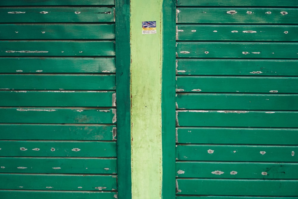 a red fire hydrant sitting in front of a green door