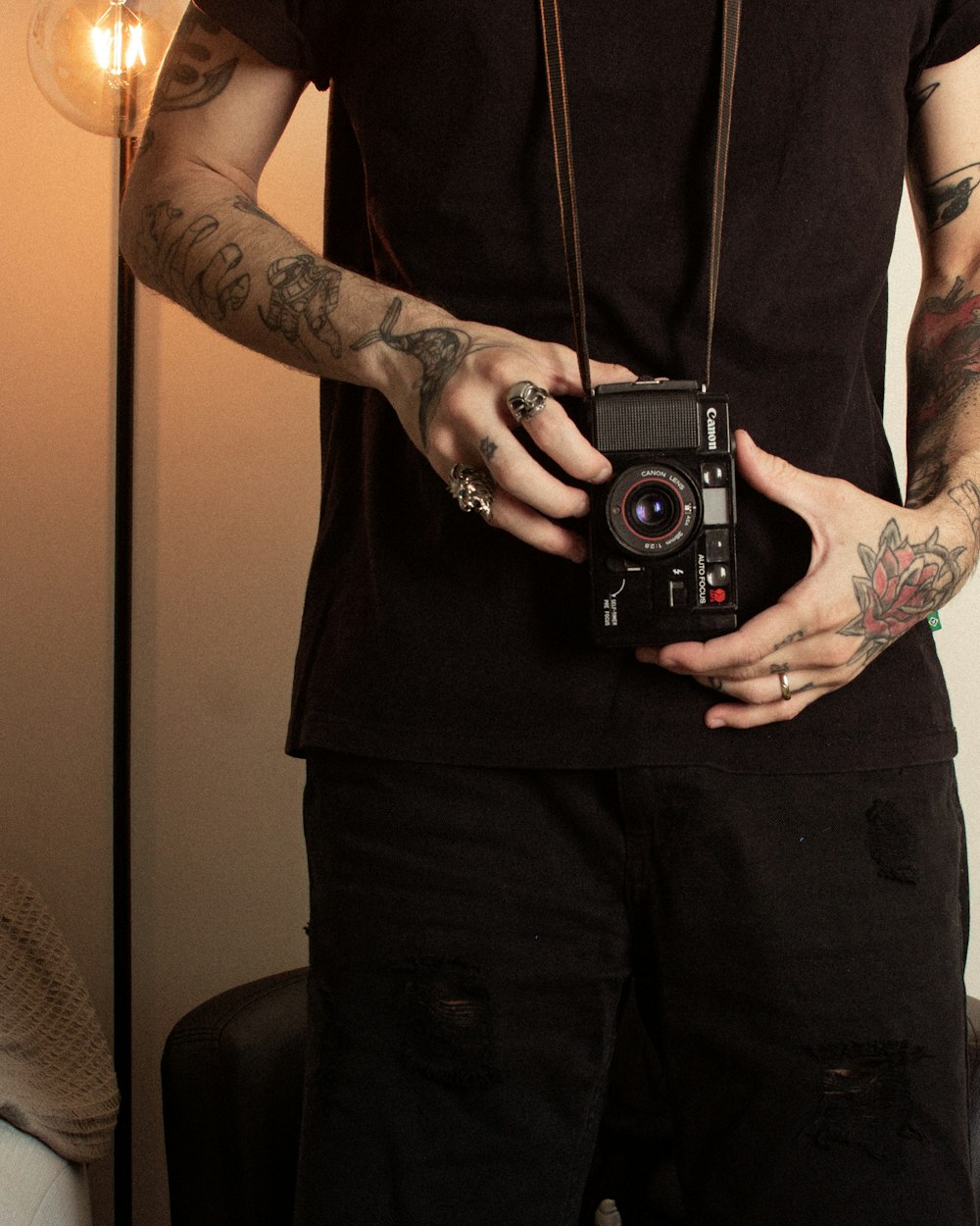 homme avec un appareil photo argentique noir