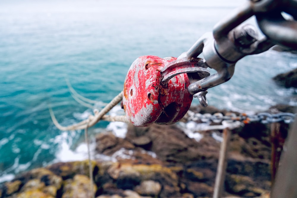 red steel pulley with ropes on body of water