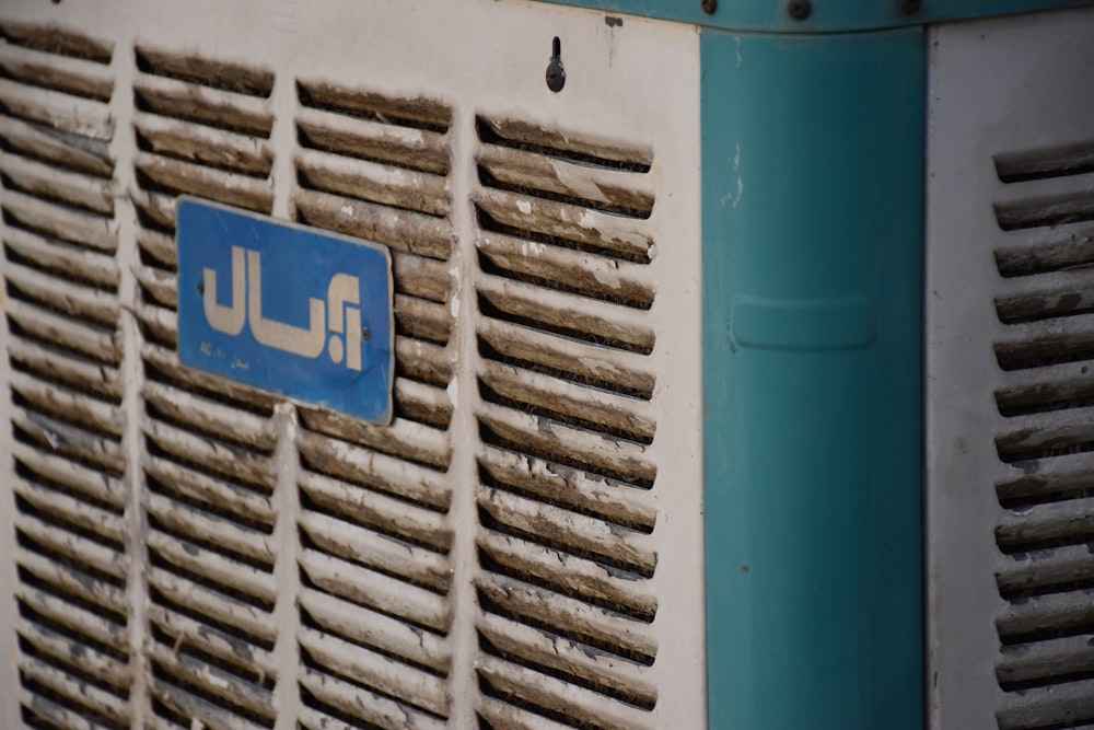 a blue and white air conditioner sitting next to a building