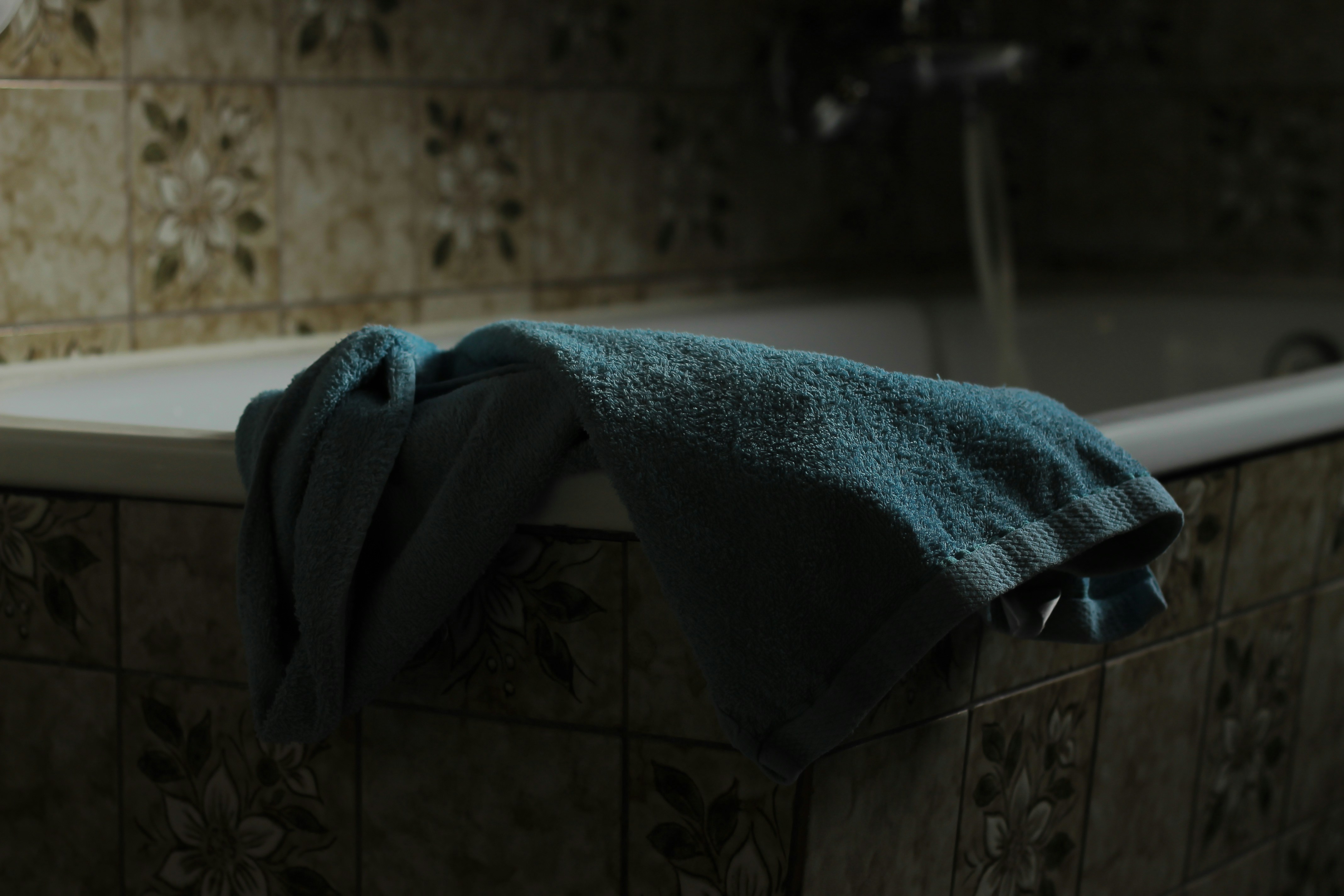 blue towel on bathtub edge