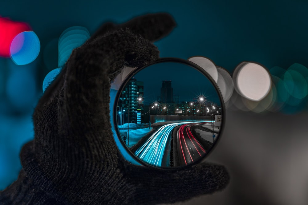 a person's hand holding a magnifying glass with a blurry image