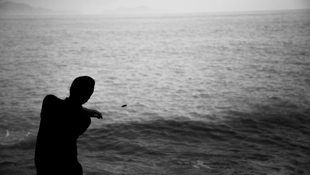 silhouette photography of man standing on shore