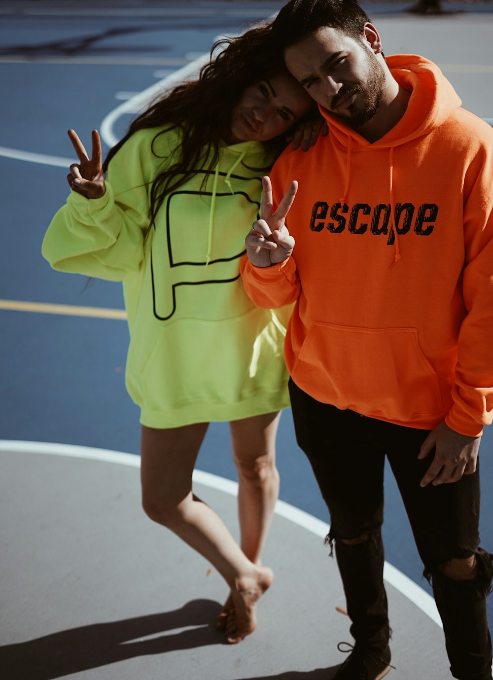 a man and a woman standing next to each other on a basketball court