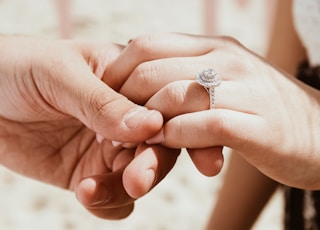 person holding another person's hand with ring