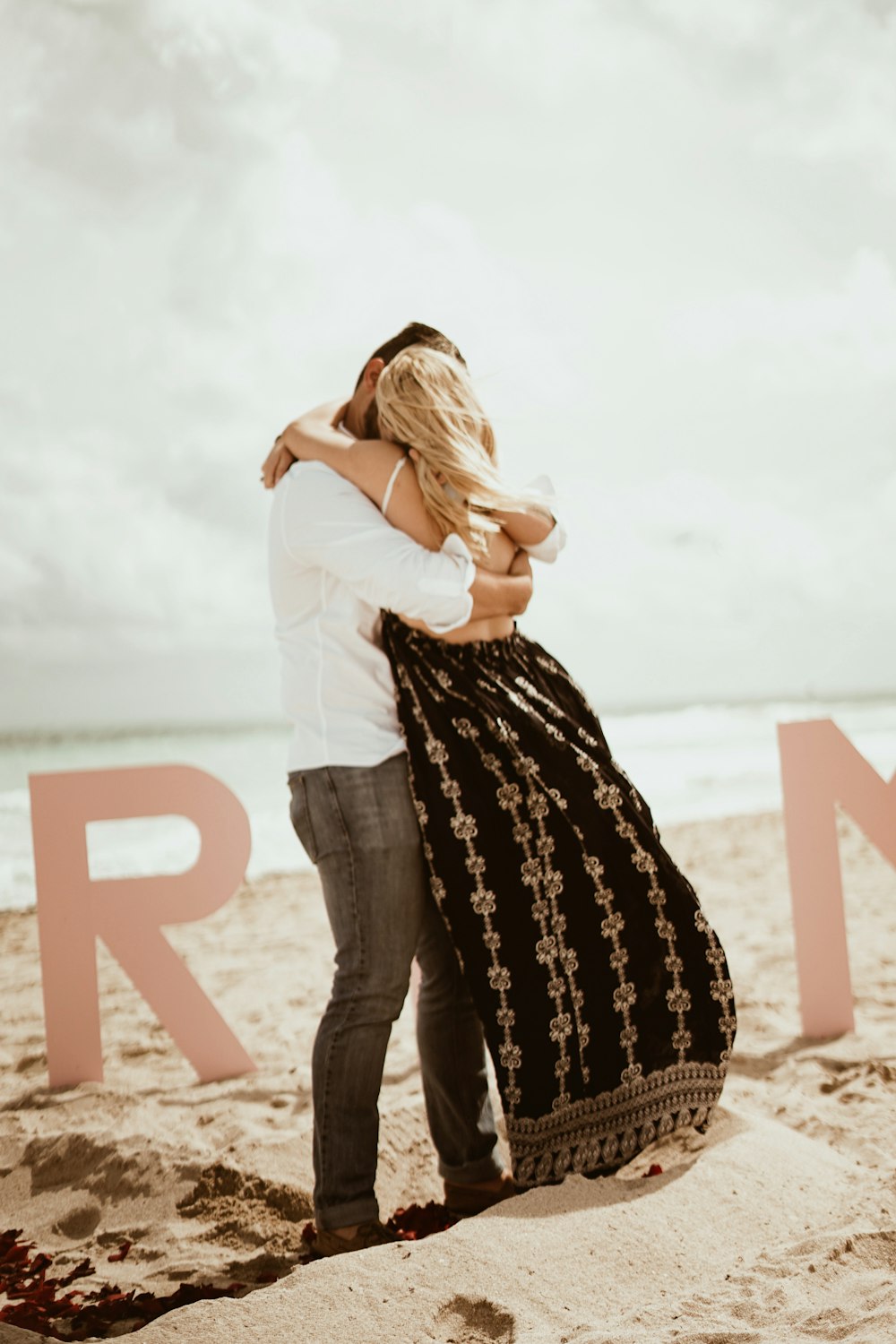 couple kissing while standing on shore