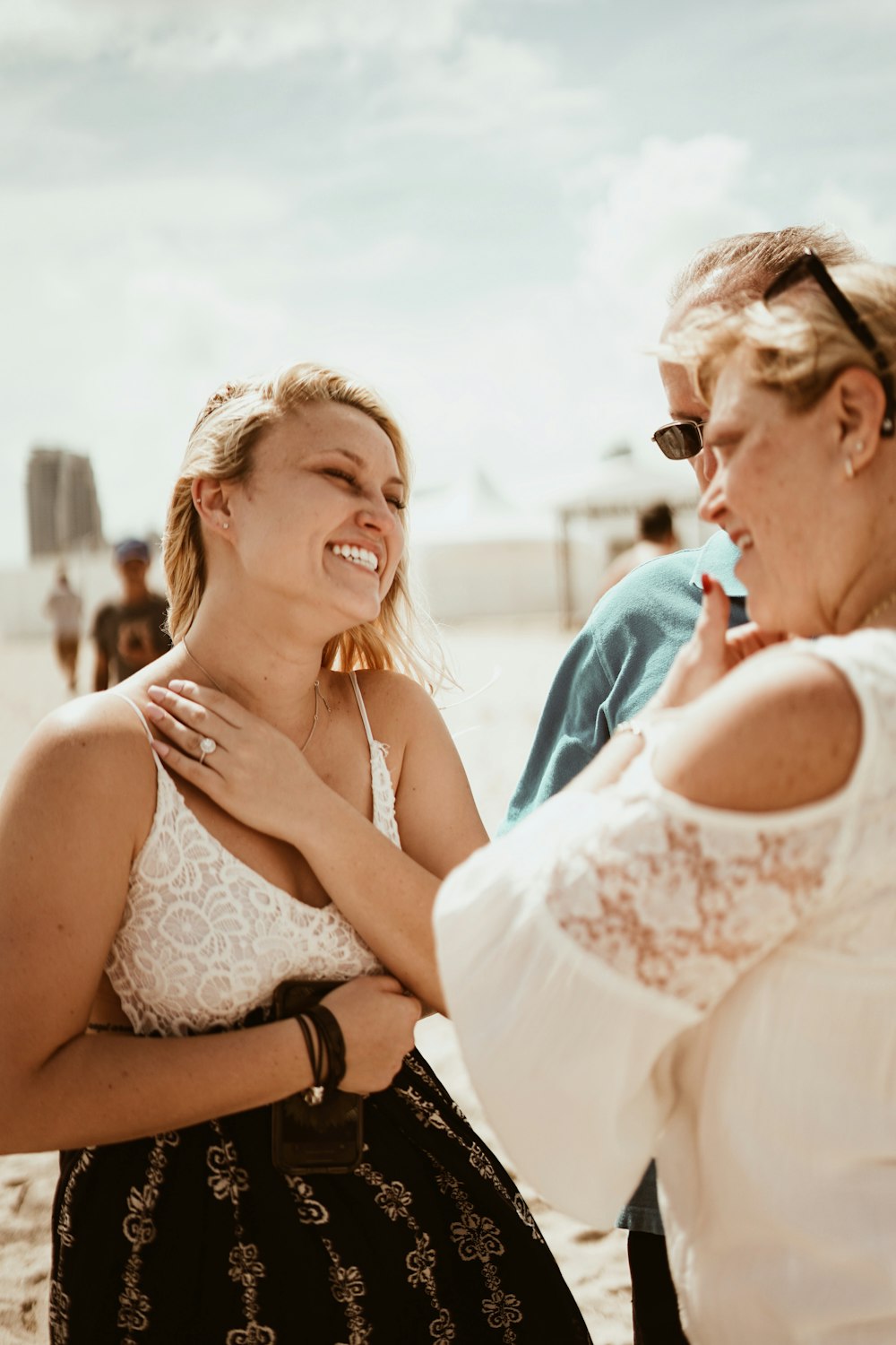 smiling woman in front of man and woman during daytime