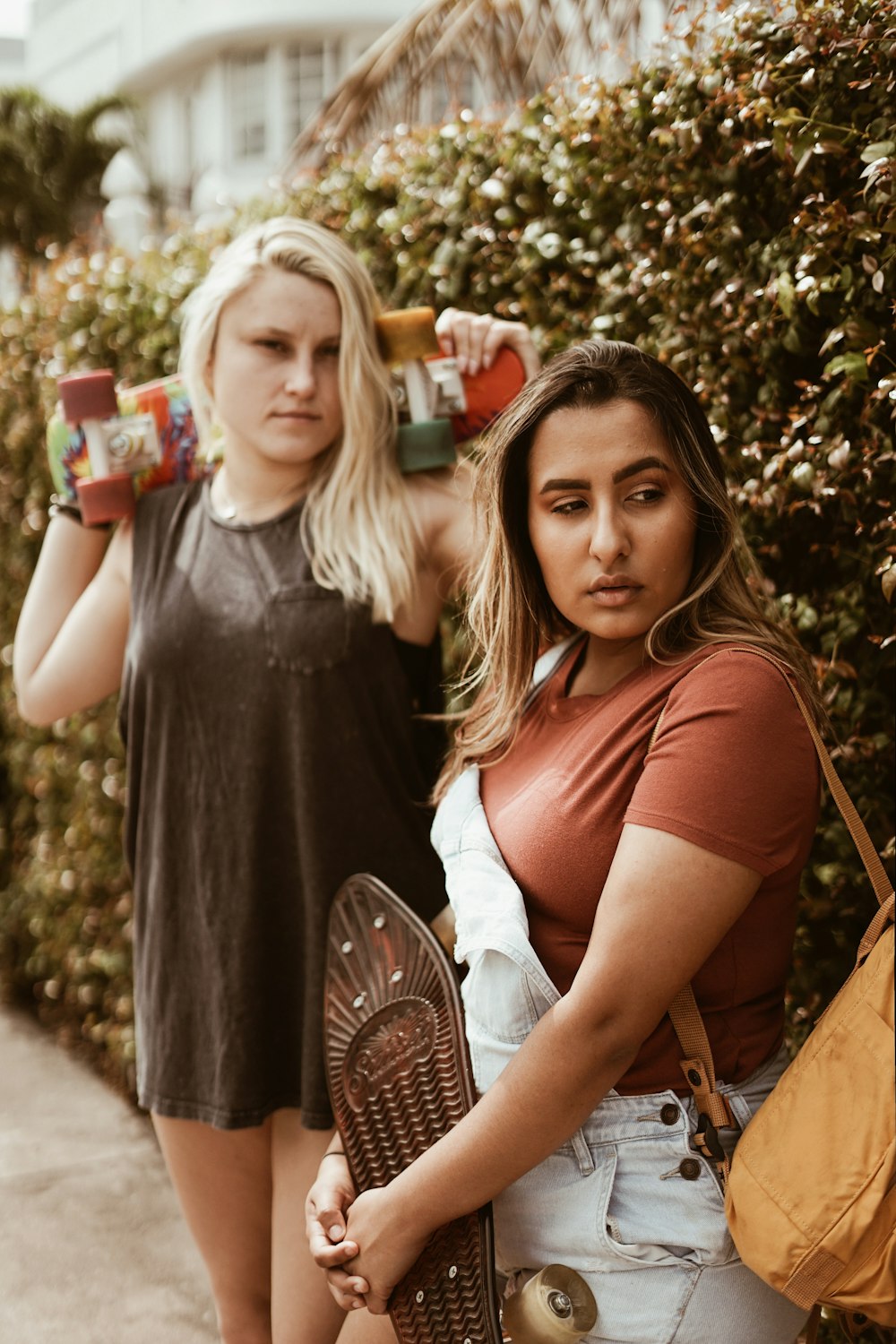 two women near hedge during daytime