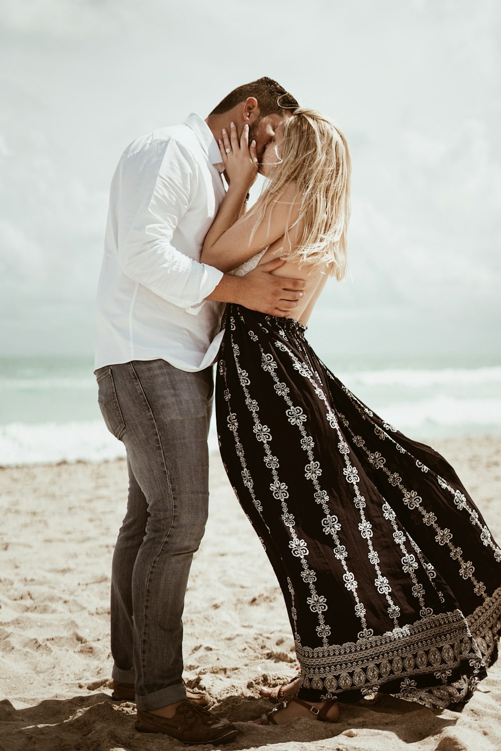昼間の海岸でキスをするカップルのセレクティブフォーカス写真