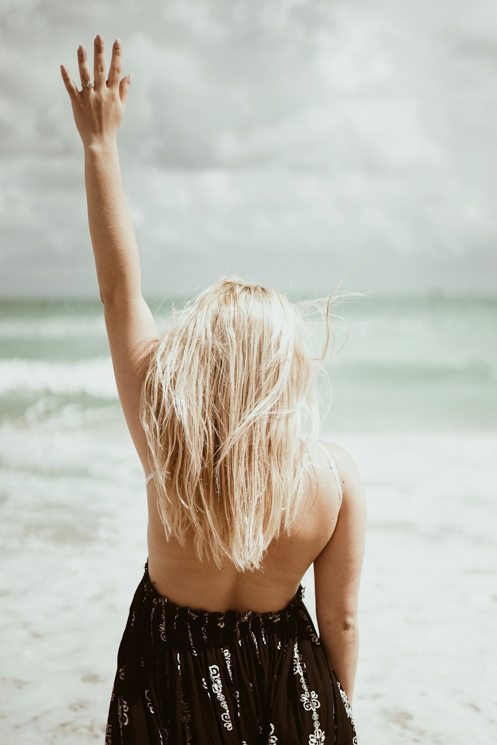 woman standing and raising left hand