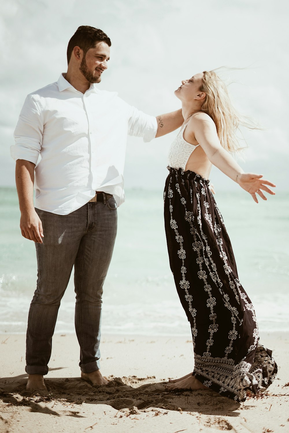 man and woman standing on seashore