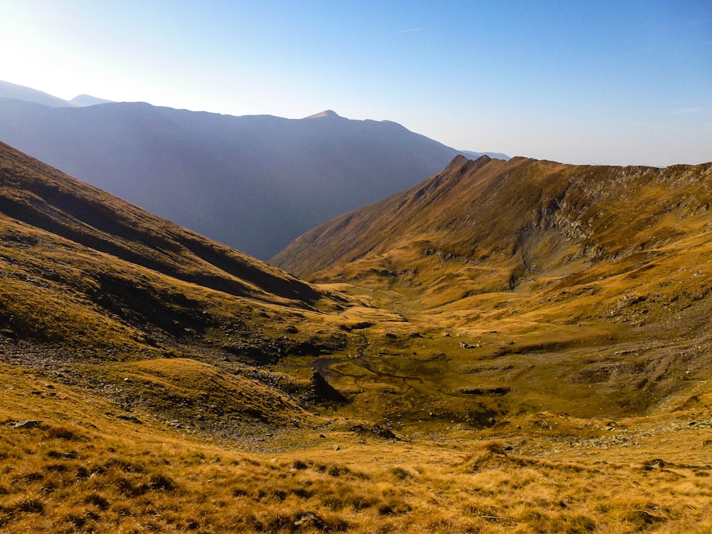 dirt covered hills and mountains during day