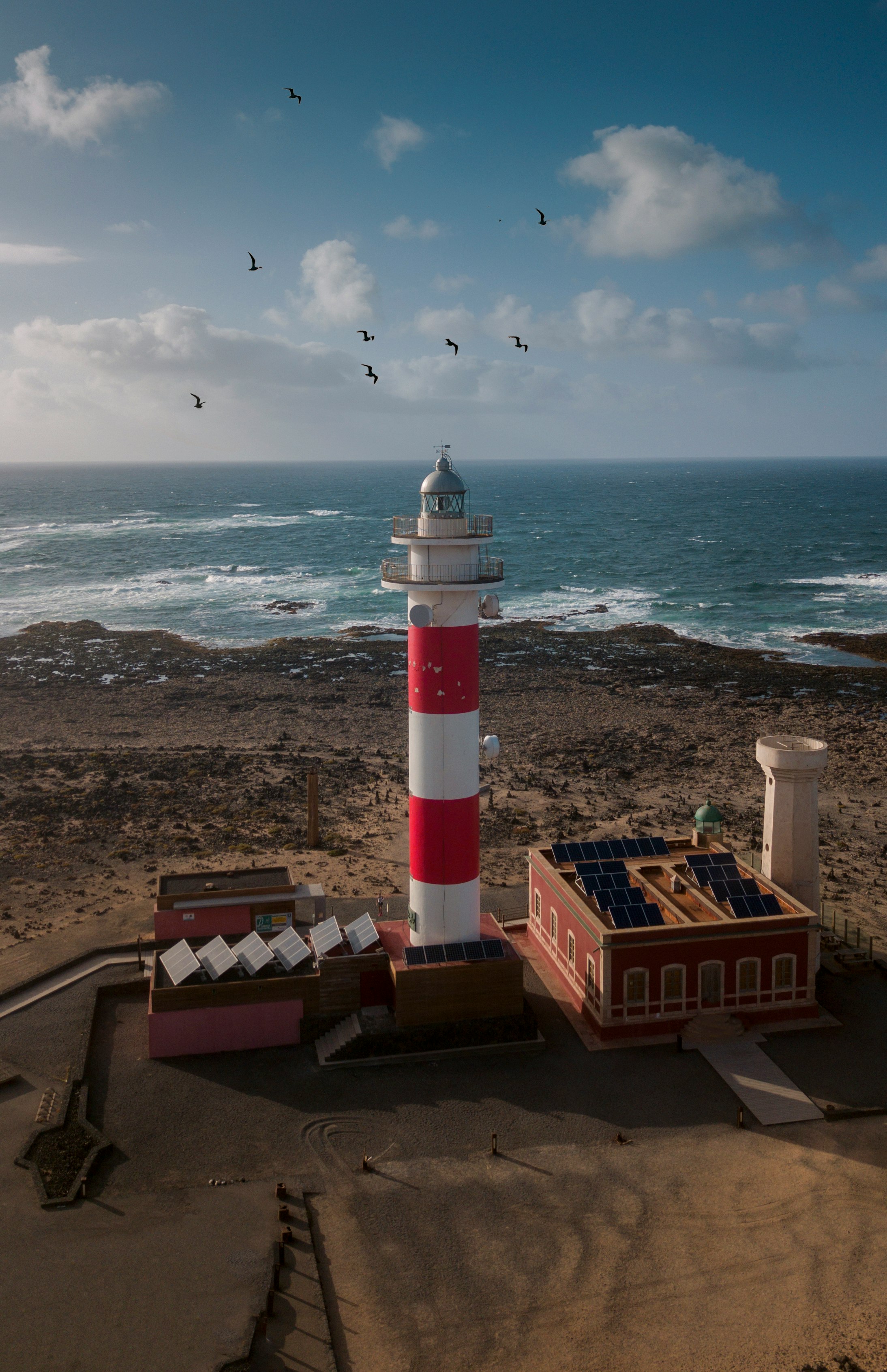 white and red lighthouse near ocean during daytime