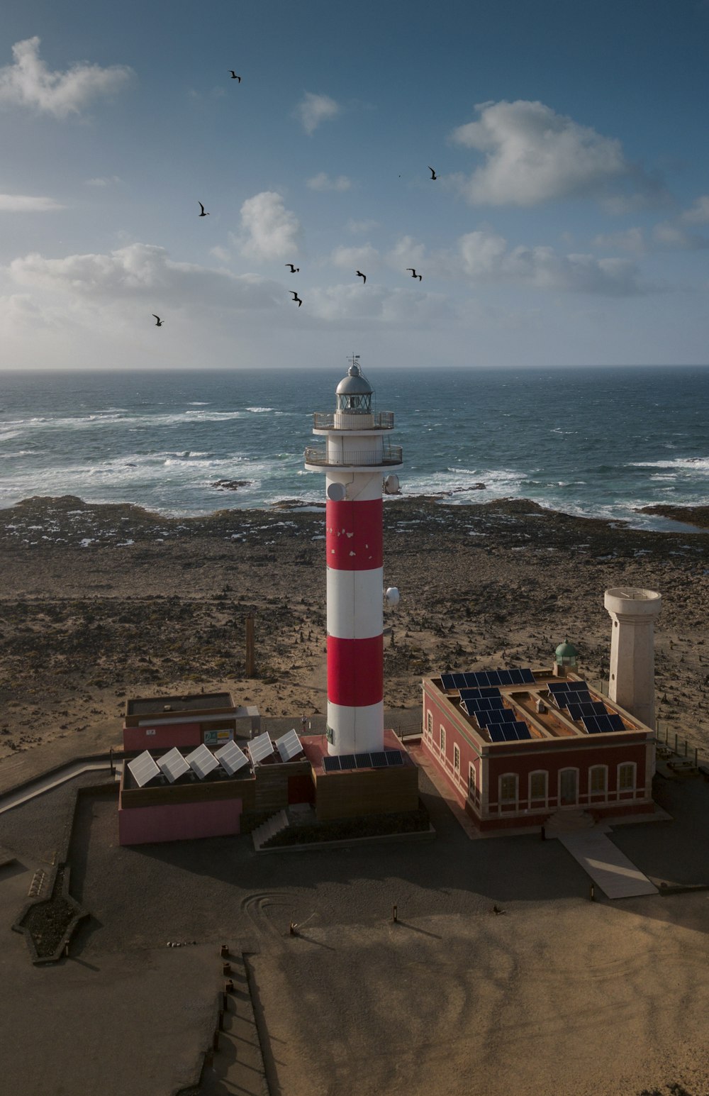 white and red lighthouse near ocean during daytime