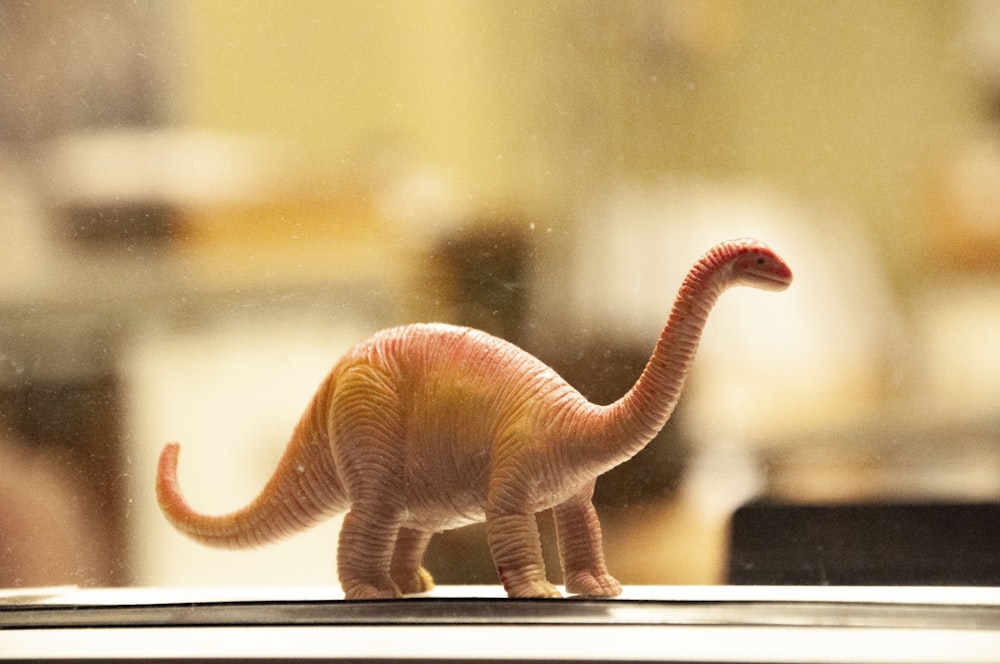 白い机の上の恐竜のおもちゃ