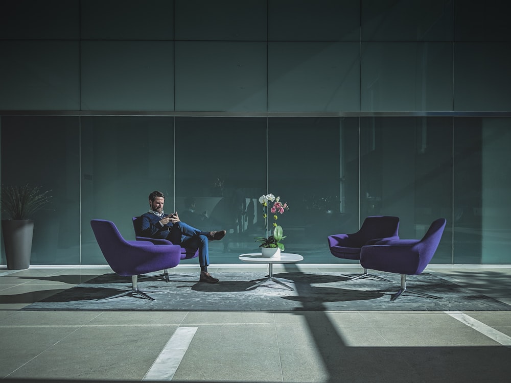 man sitting on purple cushion armchair