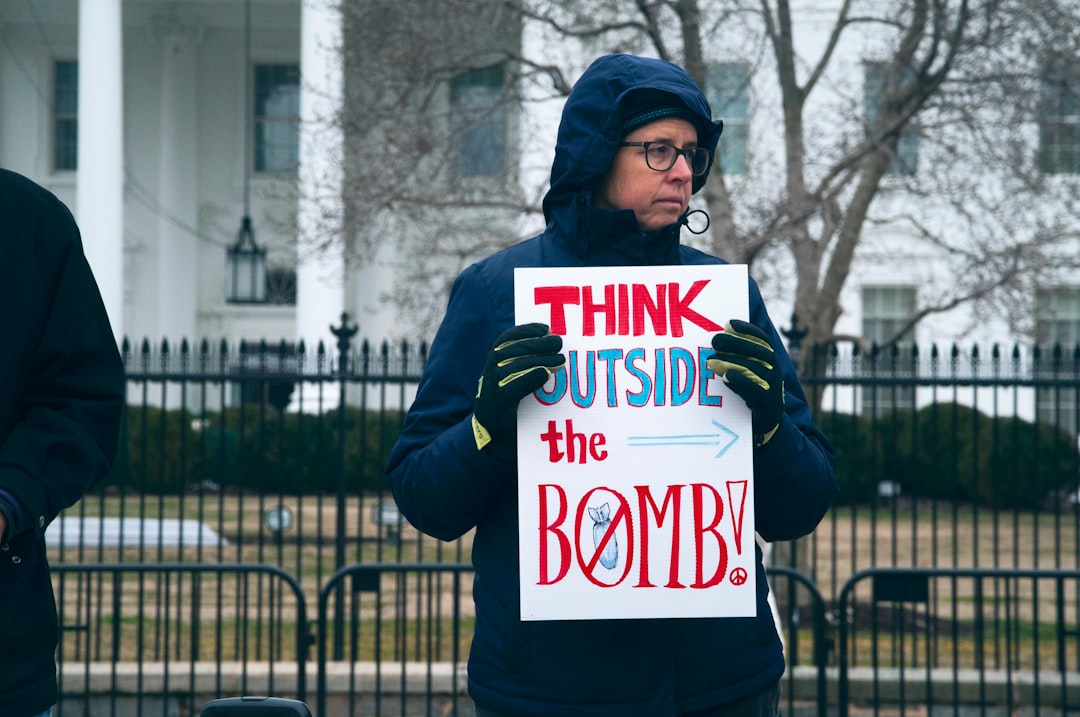 man holding think outside the bomb signage during daytime