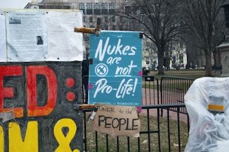 Protesters holding peace signs near a nuclear power plant.