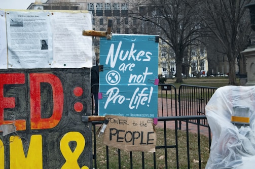 Protesters holding peace signs near a nuclear power plant.