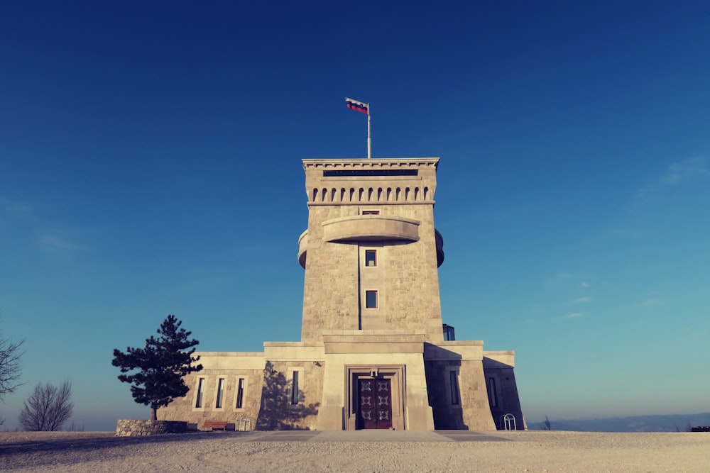 architectural photography of concrete building with flag on top