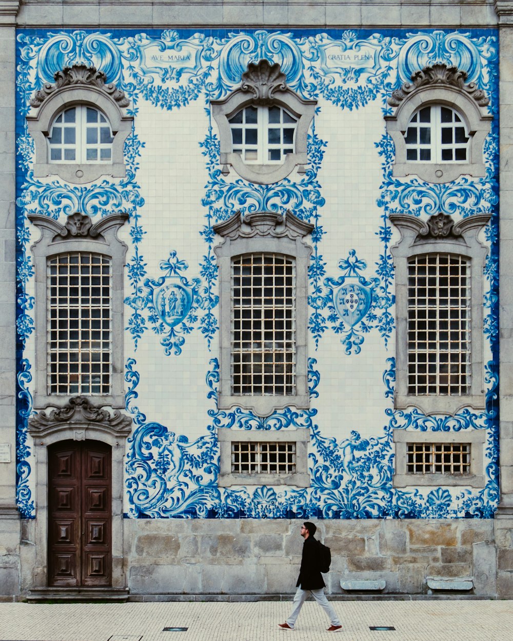 man walking on roadside near building