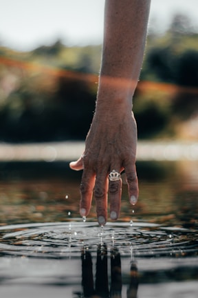 view of person's hand with gold-colored crown ring