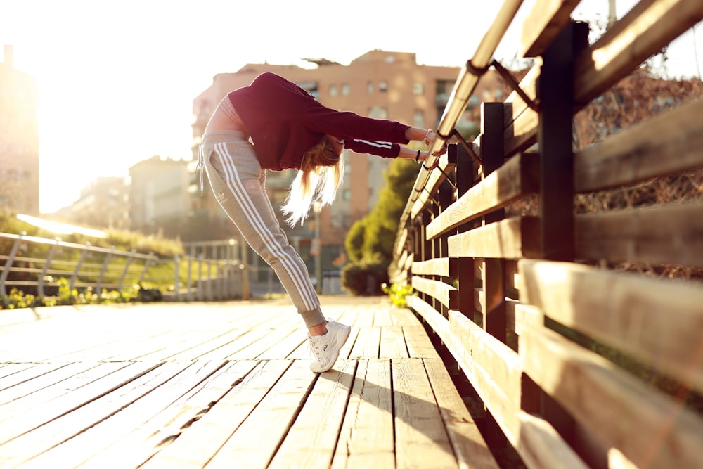 woman bending her body while holding metal bar