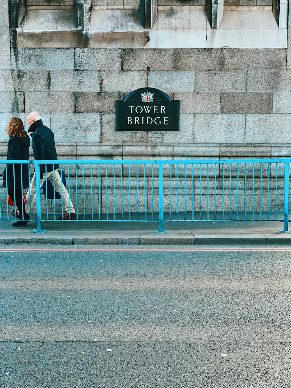 man and woman holding bag walking on sidewalk