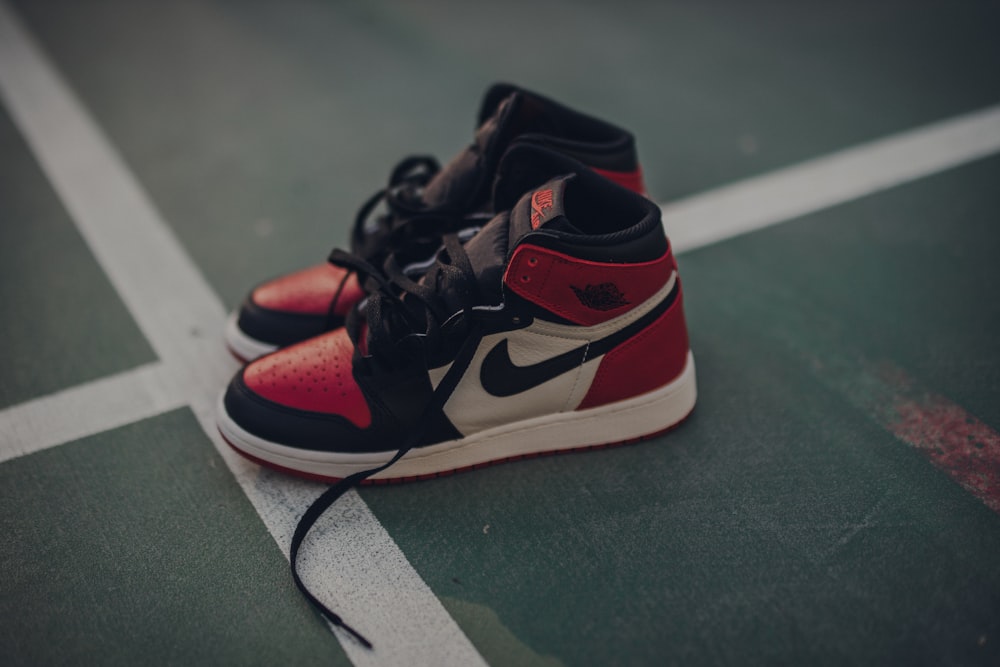 pair of white black and red Nike sneakers on floor