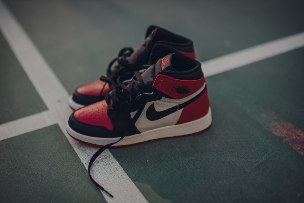 Pair of white black and red nike sneakers on floor photo – Free Sports  Image on Unsplash