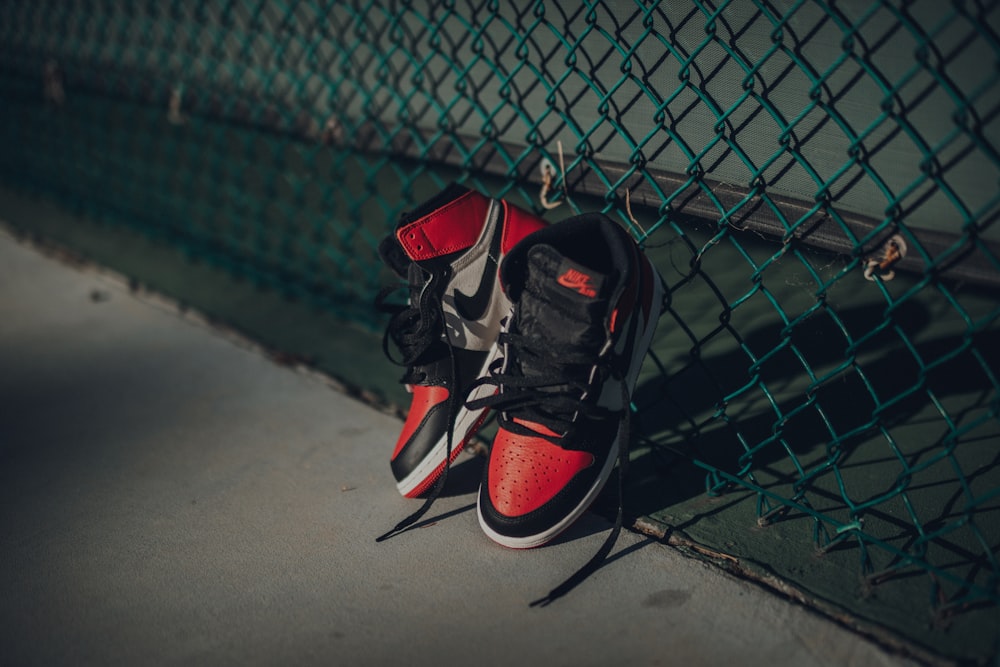 Nike Air Jordan 1 shoes near chain link fence